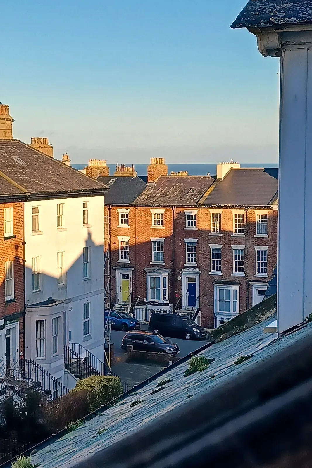 The sea on the horizon above the West Cliff rooftops, seen from an upstairs window at Bartley House