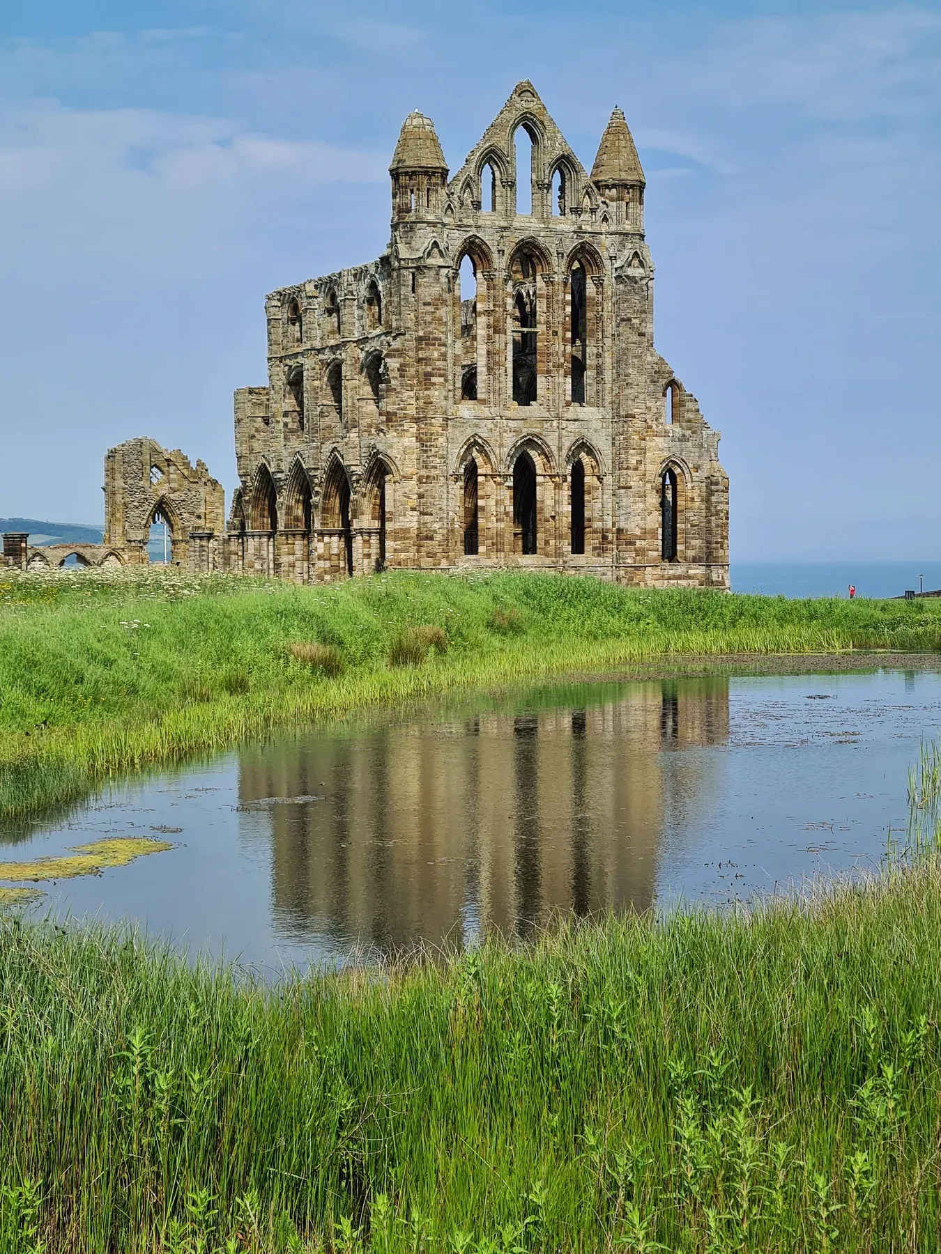 The ruins of Whitby Abbey on the East Cliff, reflected in the monks' pond
